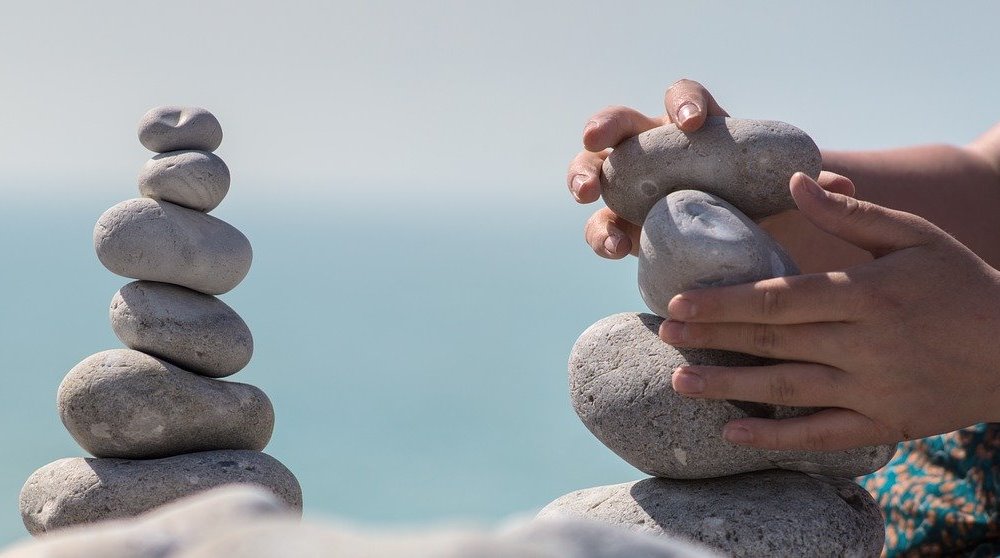 Hands Patiently Stacking Stones