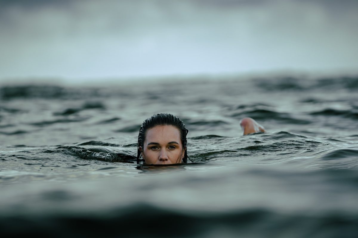 A woman's face trying to stay afloat in the middle of the ocean