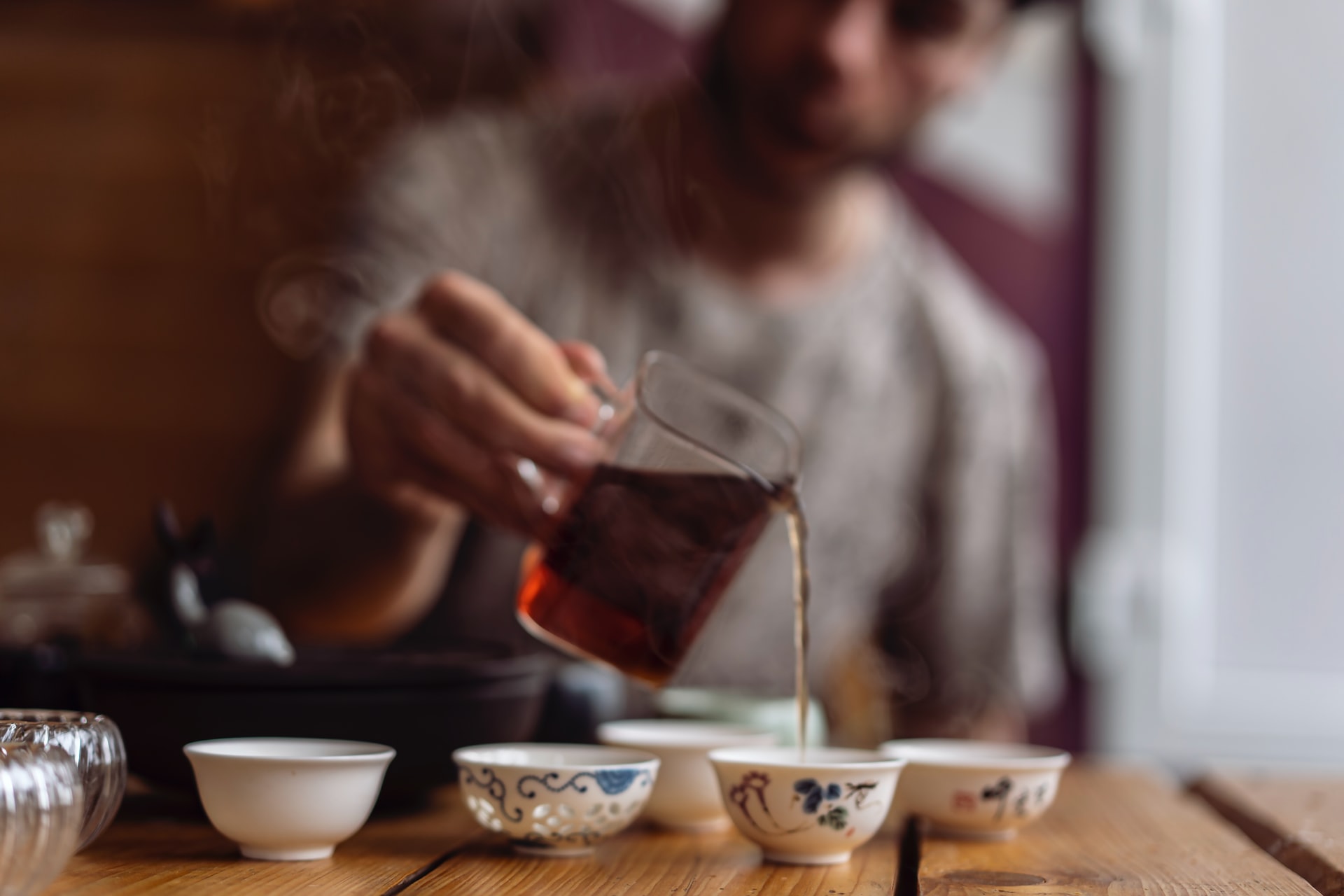 Man pouring tea to small tea cups